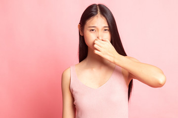 Young Asian woman  holding her nose because of a bad smell.