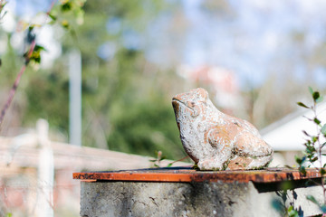 Figura de arcilla de una rana posada al sol