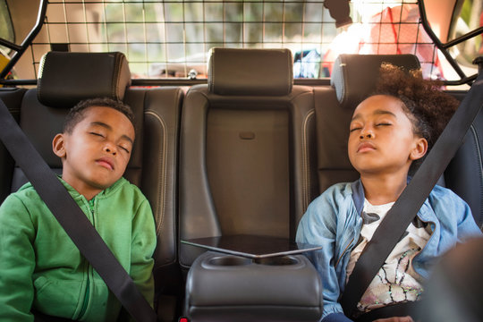 Siblings sleeping in electric car