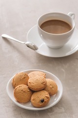 White cup of creamy coffee with butter cookies and stainless teaspoon isolated on white background, clipping path