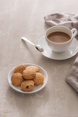 White cup of creamy coffee with butter cookies and stainless teaspoon isolated on white background, clipping path