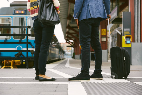 Low section of business people standing with bag at railway station