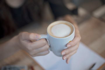 woman hands holding a cup of coffee