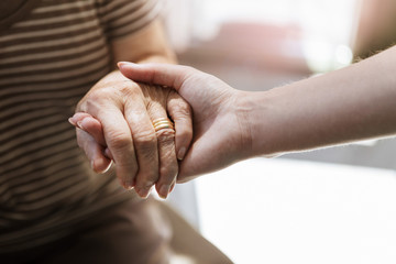 Close up of nurse holding hand of senior woman
