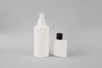 Two white bottles on a gray background. Cosmetics. Cosmetic set.