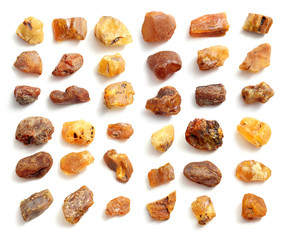 Natural raw amber stone isolated on white background. Multiple amber gemstone in various shapes and colour. Jewelry components.