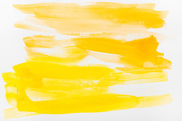 top view of yellow watercolor brushstrokes on white background