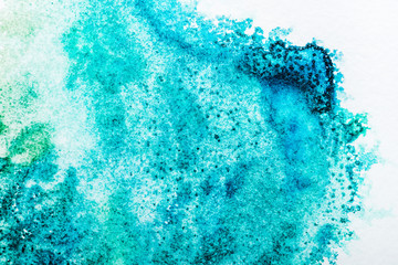 top view of turquoise watercolor spill on white background