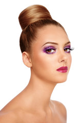 Portrait of young beautiful girl with fancy violet make-up and hair bun