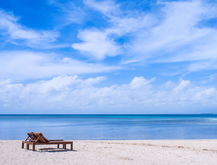 Chairs on the amazing beautiful sandy beach near the ocean with blue sky. Concept of summer leisure calm vacation for a tourism idea. Empty copy space, inspiration of tropical landscape