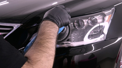 A professional bodywork and headlamp polishing worker will transport the car after painting or preparing for sale. Concept of: Freshen cars, Automotive center, Service, Professional. © dkHDvideo