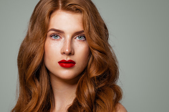 Perfect redhead woman face closeup. Red head girl with curly hairstyle and green eyes. Natural authentic beauty
