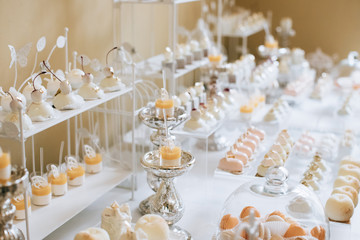 Wedding reception dessert table with delicious decorated white cupcakes 