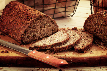 Fresh bread slice and cutting on rustic wooden table