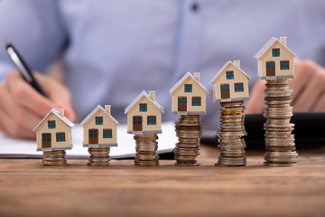Businessman Calculating Invoice With House Models