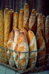 Fresh baguette in metal basket, close up vintage view