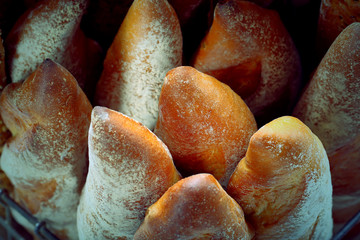Fresh baguette in metal basket, close up vintage view