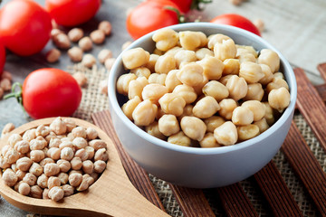 Cooked chickpeas (Cicer arietinum) in bowl on wooden background