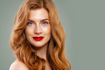 Fototapeta premium Portrait of beautiful woman with long curly ginger hair and red lips, pretty female face closeup