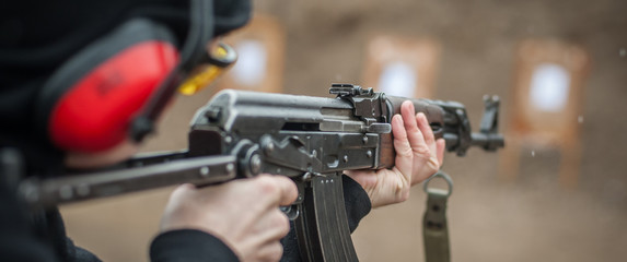 Combat riffle machine gun shooting from behind cover or barricade