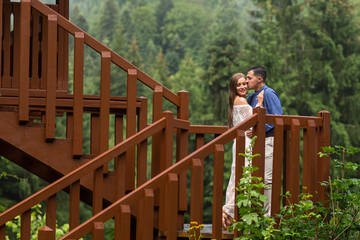 Obraz na płótnie Canvas Beautiful wedding couple posing in nature at wooden structure
