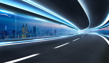 Moving on tunnel with transparent glass window and modern city skyline view .