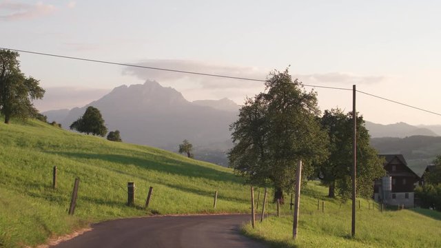Paved road leading to the farmhouse amid the splendour of the Alps, Switzerland.