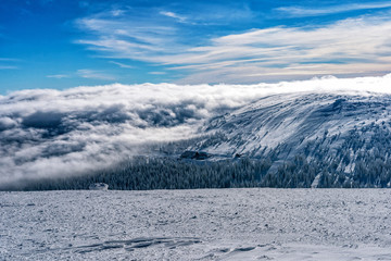 The low clouds over high mountains at winter day.