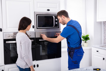 Male Technician Fixing Oven