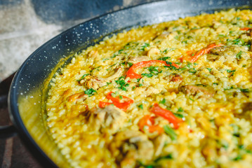 Rice and rabbit, typical dish of the gastronomy of the region of Murcia, Spain, cooked in a paella pan.