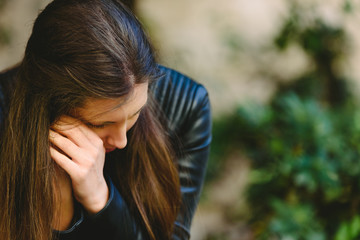 Fototapeta premium Woman victim of a couple's argument, sitting alone thinking about breaking their relationship for fear of suffering abuse