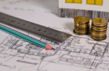 Coal pencil and metal ruler on a technical drawing of an apartment.