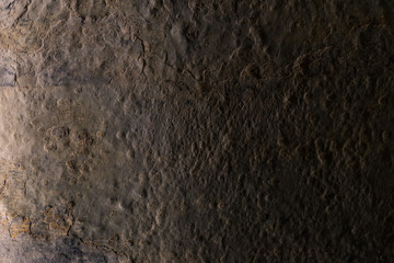 Beautiful grunge aged stone background with low light and strong texture.