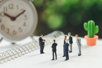 Fototapeta premium Miniature people meeting on a NoteBook . meeting or Discussion using as background business concept with copy space and white space for your text or design.