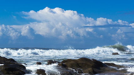 Obraz premium waves with rocks and clouds