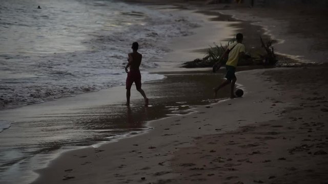 Boyz playing football at the beach
