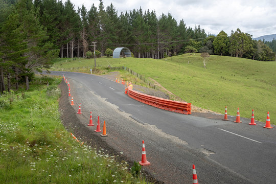Roadworks at Kaitaia Awaroa Road Northland New Zealand. Countryside hills.. Pylons along roadside. Prolapse of the road.