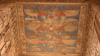 Ancient Egyptian carvings of eagle birds and hieroglyphics on the roof of an ancient temple.