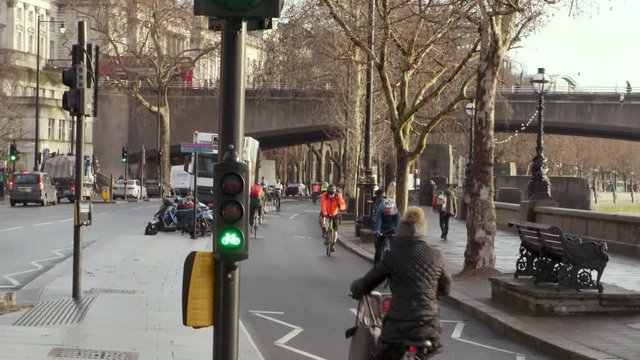 Cyclists ride in a busy cycle lane in London with cycle traffic lights