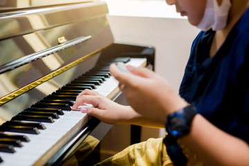 Selective focus of kid play the piano with smart phone for learning music
