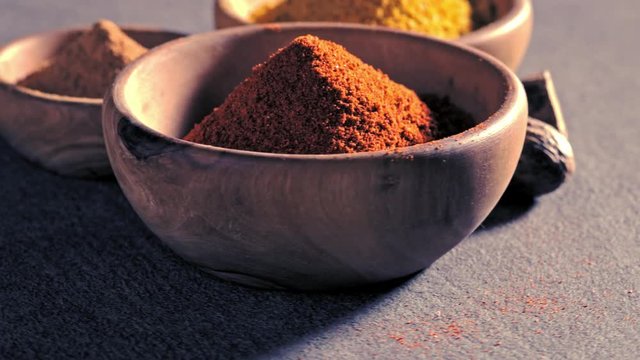 Peppers, turmeric and cinnamon in bowls spinning on the table