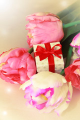Fototapeta na wymiar pink tulips and decorative gift box with a bow for the holiday of March 8