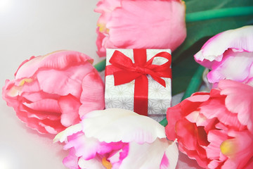 pink tulips and decorative gift box with a bow for the holiday of March 8