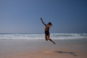 Fototapeta na wymiar Happy girl jump on the beach