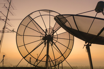 aerial view sunrise on the old satellite dish collapsed on the roof of the tall building.