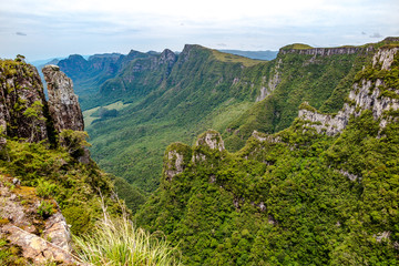 Fototapeta na wymiar Rock Walls of Serra General view of Espraiado Canyon, with lots of vegetation, cloudy sky, city of Grão Para, Santa Catarina, Brazil