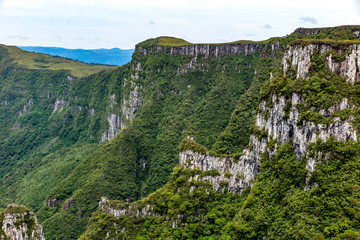 Fototapeta na wymiar Walls of the Espraiado Canyon,, with lots of vegetation, blue sky with clouds, city of Grão Para, Santa Catarina, Brazil