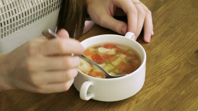 Healthy food. Close-up shot of young blonde woman eating vegetable soup at restaurant. 4K