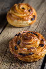 Fresh buns with raisins on a wooden table