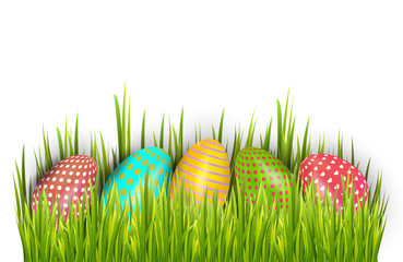 Row of Easter painted eggs hidden in green grass and isolated on white background.